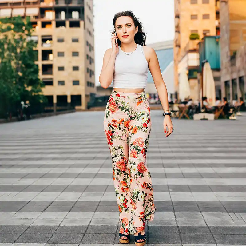 Woman in floral pants talking on phone.