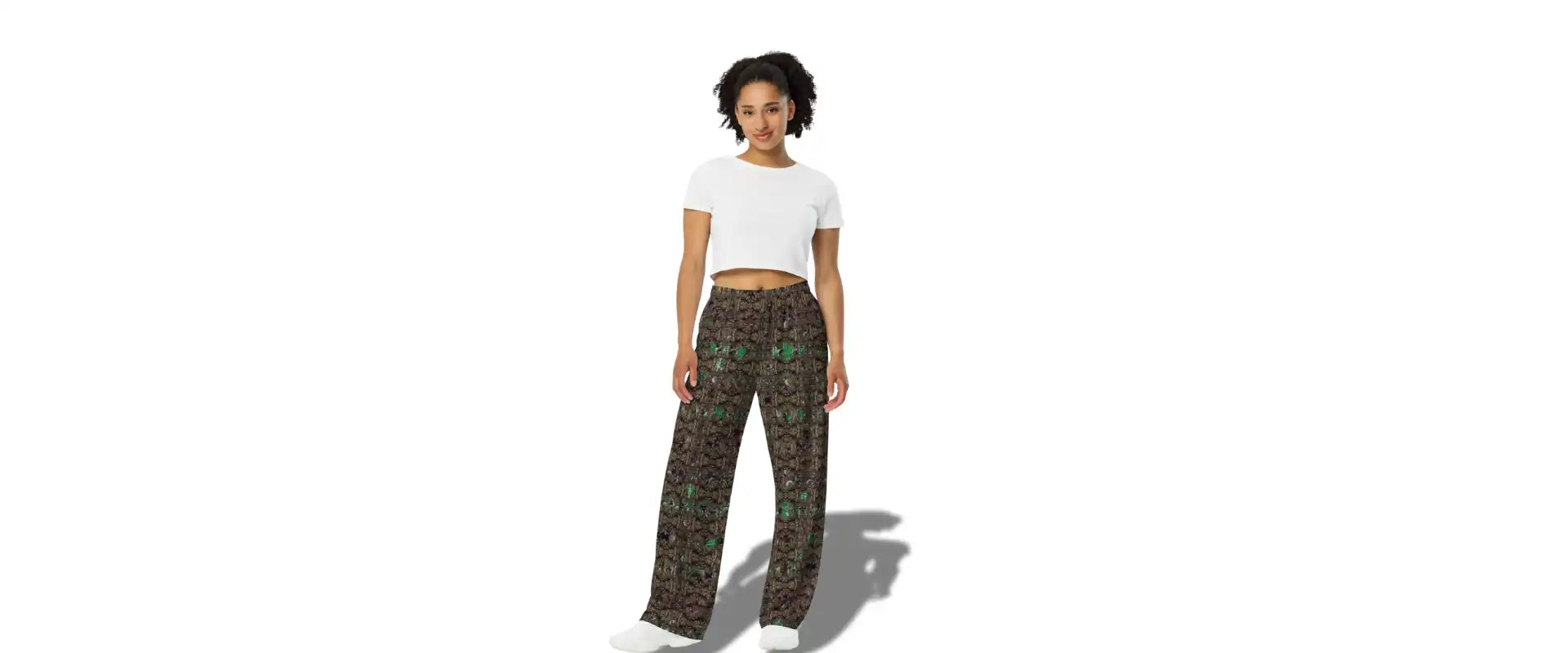 A woman in a white crop top and patterned wide-leg pants.